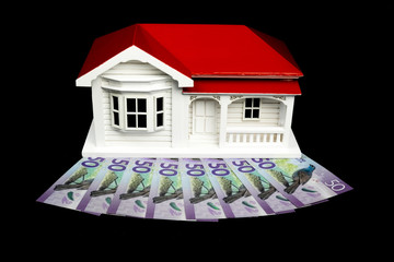 Bungalow villa house model with New Zealand NZ Dollars on black background