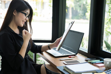 businesswoman glad with successful project at workplace. young happy woman work with new business plan at office. manager raise her fist with gladness