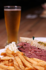 smoke meat sandwich with fries and a beer
