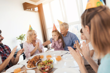 Parents, grandparents and brother congratulate the little girl on her birthday