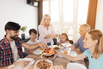 The family gathered for a festive dinner for Thanksgiving. Everyone puts food in plates