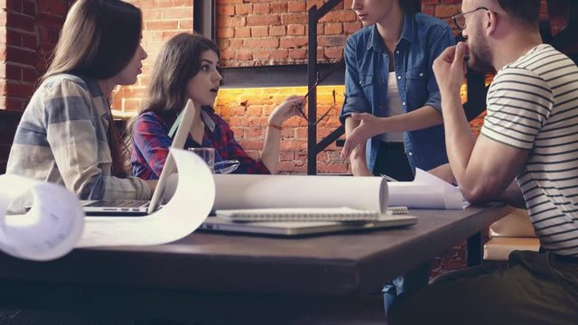 Young people discuss a project in the workplace