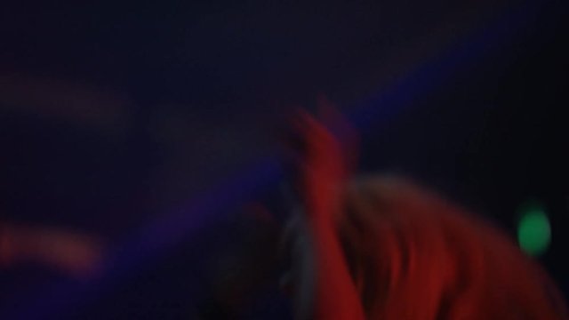 	 Close up girl in a crowd, listening to the band & dancing at live music even