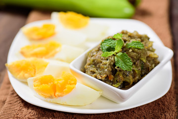 Thai Northern food (Tum Makeua Yao).Grilled green eggplant pounding with chili and spices and eating with boiled egg