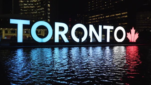 Toronto Sign Reflection of Illuminated Blue and Red Lights at Night