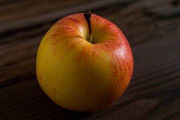 Ripe red apple on rustic dark wooden table