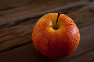 Ripe red apple on rustic dark wooden table
