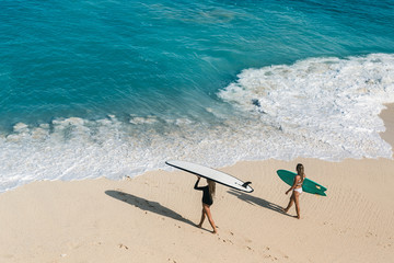 Beautiful young woman in bikini with surf board at beach of tropical island. - obrazy, fototapety, plakaty