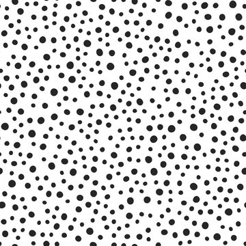 Black round spots scattered on white background. Seamless pattern. Irregular polka dot. Drawn by hand.
