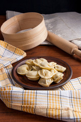 Boiled Ukrainian meat dumplings or ravioli on wooden background.