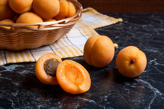 Fresh organic apricots in basket. Group of harvested apricots in basket..