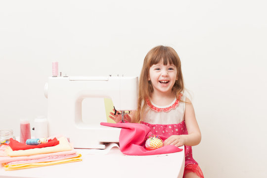 The girl is engaged in needlework using sewing machine