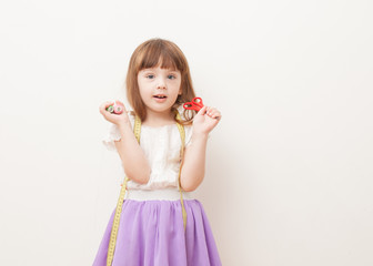 Girl with scissors, centimeter and sewing thread in the hands