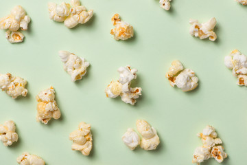 The popcorn in paper cup on green background.