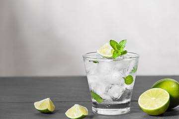 Mojito cocktail with lime and mint in glass on a grey stone background