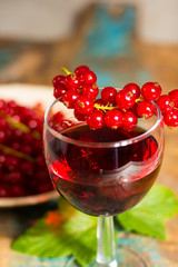 Fresh ripe red currant berries and liqueur on the table