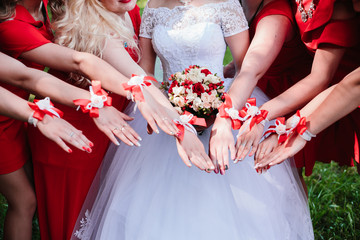 The bride and bridesmaids are showing beautiful flowers on their hands.