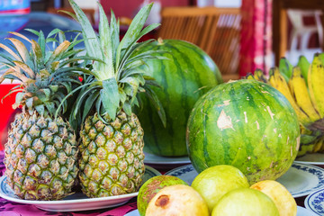 Fruit platters, including pineapple and watermelon, on table in Tanah Lot, Bali, Indonesia.