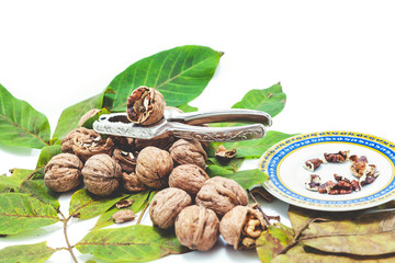 Obraz na płótnie Canvas pile of walnuts lying on leaves. Near Nutcracker and saucer