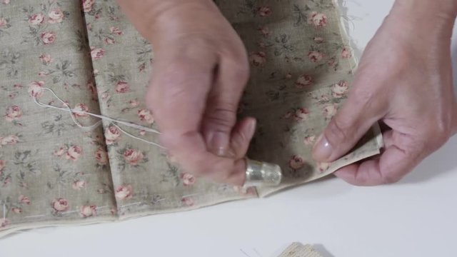 seamstress woman hands sewing for finish a quilt.