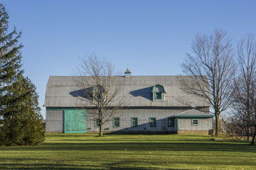 Obraz premium farm building with green grass and blue sky