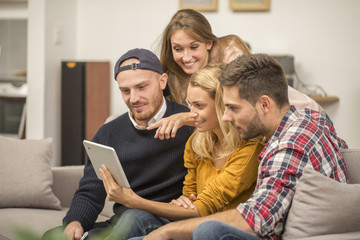 Roommates in apartment using a tablet