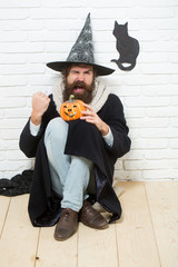 Halloween hipster with pumpkin and black cat symbol on wall