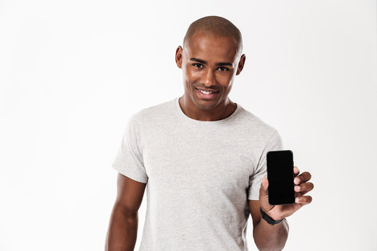 Cheerful young african man showing display of mobile phone.
