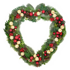 Fototapeta na wymiar Decorative heart shaped christmas wreath with red and gold bauble decorations, holly, mistletoe, ivy, snow covered winter greenery on white background.