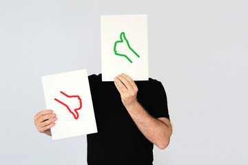 Man holding the  thumbs up and thumbs down icons. Social media and costumer feedback concept. Empty copy space for Editor's text.