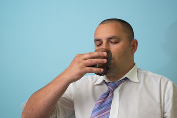 Businessman with a cup on blue background