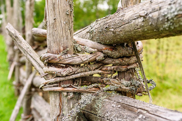Fototapeta na wymiar Traditional Scandinavian round pole fence binding made of young sapling wood.