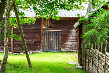 Vintage Scandinavian farm environment with wooden barn and old pole fence as border to the front yard.