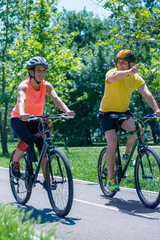 Fototapeta na wymiar Young couple riding bicycle on summer day