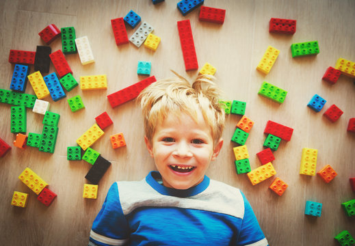 happy cute little boy love playing with plastic blocks
