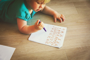 little girl learning to write letters
