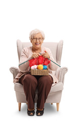 Mature woman seated in an armchair knitting