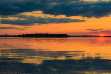 sunset over the transylvania lake in Umbria Italy intense late summer colors in the pier