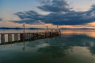 Naklejka premium sunset over the transylvania lake in Umbria Italy intense late summer colors in the pier