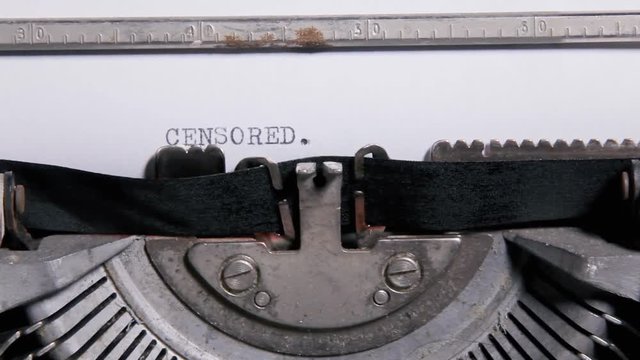 Typing the word - Censored - on a sheet of paper with an old vintage typewriter.
