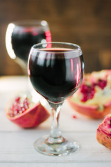 Organic pomegranate wine on white wooden table.