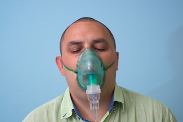 Portrait Of Young Man Inhaling Through Inhaler Mask