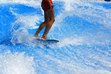 Muscular young athletic sexy boy surfing in the water