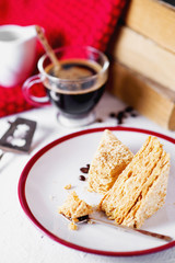 sweets and desserts, cakes and pastries, Napoleon with puff pastry, custard and a cup of black coffee on a light background
