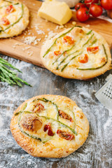 Mini pizza with asparagus. Traditional small pizza for personal eating filling with cheese, tomatoes and asparagus.