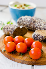 Bunch of cherry tomatoes over wooden board.