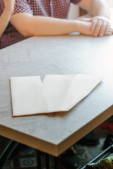 Empty paper flyers for menu on table at cafe or restaurant.