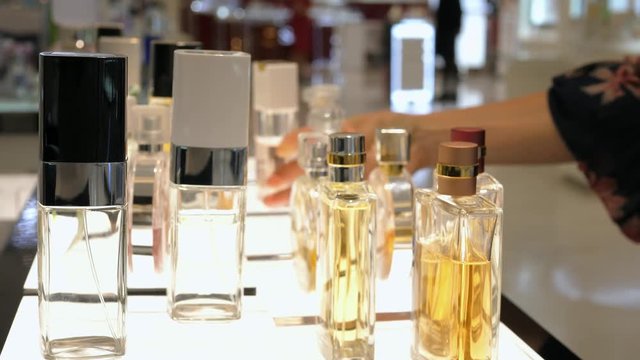 Female Hand Choosing Luxury Parfume In Cosmetic Store. Closeup. 