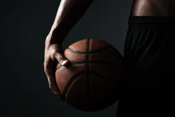 Fotobehang Cropped photo of basketball player holding ball © Drobot Dean