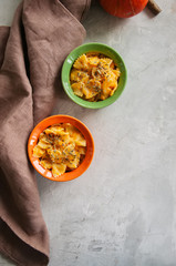 Pumpkin creamy mac and cheese baked pasta over white stone background. Comfort food.